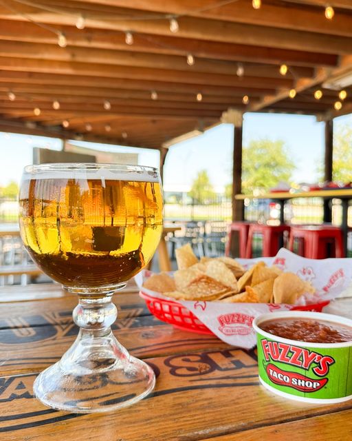 An image of salsa and chips and a beer